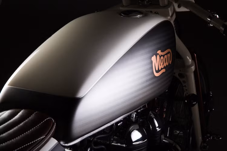 Giống các bản độ khác từ Mean Machines, chiếc Triumph Bonneville với tên gọi Rumour Monger này cũng có nước sơn đầy tính hoài cổ và nghệ thuật, với logo Mean trên bình xăng và những đường kẻ ngang chạy suốt chiều dài thân xe.