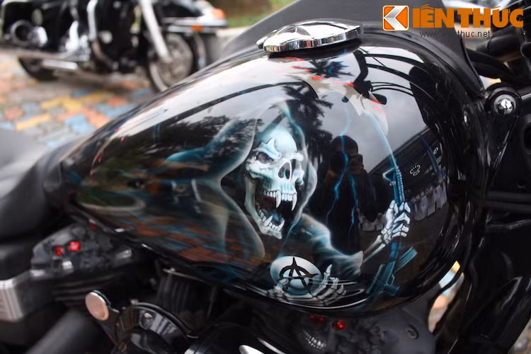 Trong khi đó, bình xăng lớn của xe được vẽ airbrush "độc nhất vô nhị", hình ảnh với tử thần cầm súng ở tay trái và giữ trên tay viên ngọc có logo Son of Anarchy ở tay còn lại.