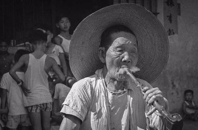 Một người phụ nữ ở Cửu Long đang hút tẩu thuốc. Ảnh xilu