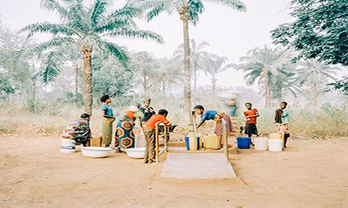 Mọi người tập trung lấy nước tại một giếng nước bơm bằng tay ở Osukputu, Benue, Nigeria, năm 2015.