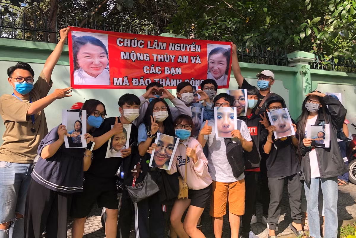 Nhóm bạn trẻ đứng hò reo, căng băng rôn, giơ hình chân dung khi kết thúc buổi thi tốt nghiệp THPT 2020 tại điểm Trường THPT Trưng Vương để động viên tinh thần cho bạn cũng từng làm netizen "cười lăn cười bò".
