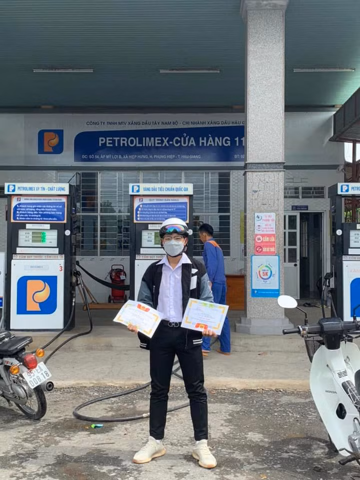 Cậu bạn này đã đưa luôn tờ giấy khen ra hẳn cây xăng check in luôn cho hoành tráng. Ảnh: Nguyễn Thành Đạt/Group Trường Người Ta