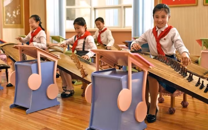Các em học sinh nữ đang học chơi một loại nhạc cụ truyền thống của Triều Tiên.
