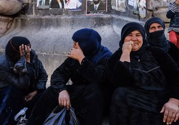 Những người phụ nữ Syria trong bộ trang phục màu đen trò chuyện vui vẻ trên đường phố.
