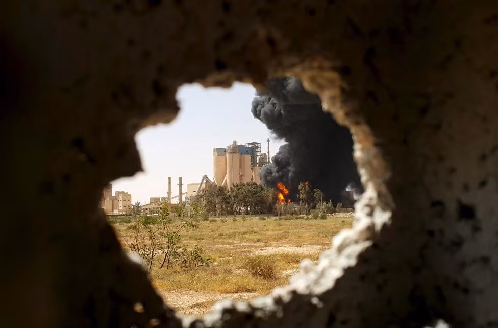 Đám cháy cạnh một nhà máy xi măng Libya trong các cuộc giao tranh giữa lực lượng quân sự ủng hộ chính phủ miền đông Libya với Hội đồng Shura cách mạng Benghazi, lực lượng đồng minh của quân nổi dậy chống Gaddafi, ở Benghazi, Libya, ngày 14/4/2016.