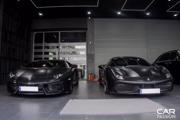 Cụ thể, bộ đôi siêu xe đến từ Ý vừa được chủ nhân của một showroom tại Sài Gòn cho khoác lên một lớp áo đen mờ vô cùng cá tính. Không chỉ mang đến một cái nhìn mới, lớp decal đen mờ này còn giúp cho siêu xe Lamborghini Aventador và Ferrari 488 GTB mang vẻ lạnh lùng hơn.