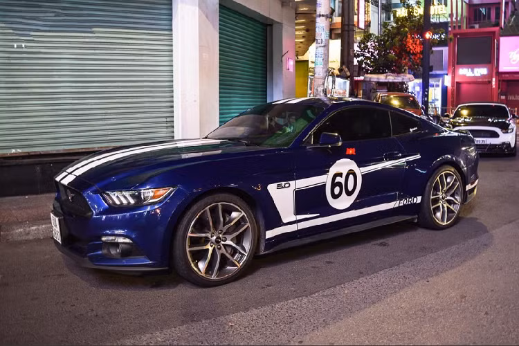 Lần họp mặt này còn có sự xuất hiện của chiếc Mustang GT hiếm hoi được trang bị động cơ V8 5.0 lit. Tại Việt Nam, đa số những chiếc Mustang đều thuộc phiên bản EcoBoost với dung tích chỉ 2.3 lit. Kết hợp với màu áo xanh của chiếc xe chính là lớp decal màu trắng bắt mắt. Ta có thể dễ dàng nhận thấy lớp decal này được lấy cảm hứng từ Heritage Edition – Một màu đã vốn quen thuộc trên nhiều mẫu xe thể thao của Ford.