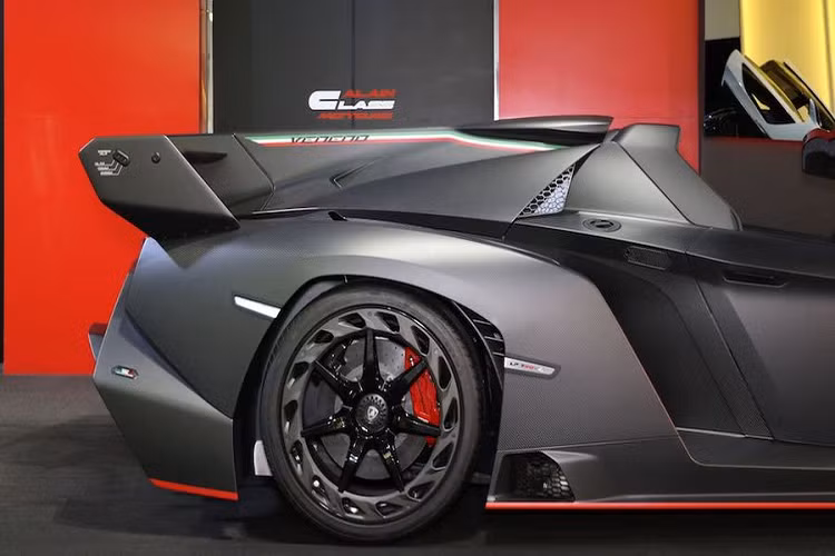 Thân xe sợi carbon của siêu xe mui trần được tô điểm thêm bởi một sọc đỏ mảnh ôm lấy các vòm bánh trước và sau, kết hợp cùng nhiều chi tiết màu đỏ nổi bật trên bộ chia gió trước, hai bên hông, bộ khuếch tán mạnh mẽ phía sau và cánh gió đuôi.