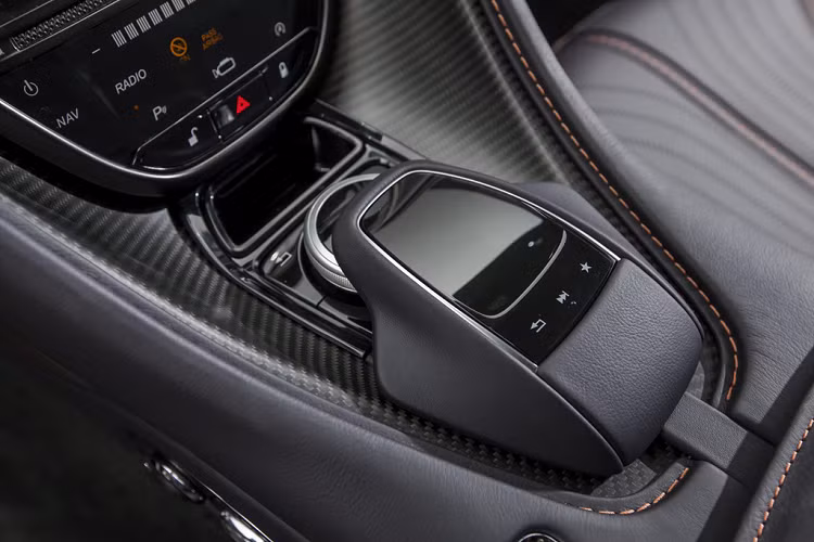 Aston Martin DB11 được loại bỏ cần số truyền thống, thay vào đó là bộ chuyển số được thiết kế dạng nút bấm đặt bên dưới màn hình giải trí. Lẫy chuyển số và các chế độ lái được đặt trên vô-lăng.