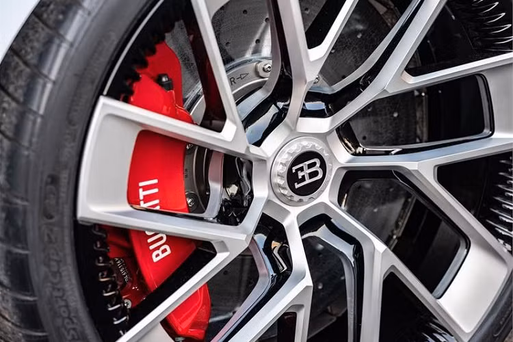 Bên sườn của Bugatti Centodieci xuất hiện bộ vành hợp kim sơn màu trắng phối đen ấn tượng. Nằm sau bộ vành này là cùm phanh màu đỏ đập vào mắt.