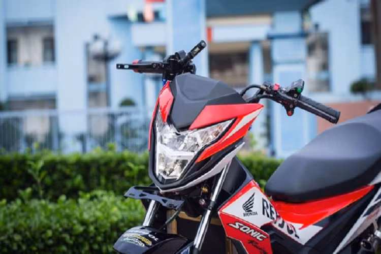 Chiếc xe Honda Sonic 150 độ thuộc phiên bản Repsol chính hãng trắng cam nhập khẩu từ Indo, tuy nhiên chủ xe đã sửa lại tông màu của dàn áo thành phiên bản Repsol đỏ để tạo sự khác lạ cho chiếc xe độ. Ngoài các chi tiết nhỏ như ống dẫn nước giải nhiệt và cổ pô Titan ra ta còn thấy chiếc xe có rất nhiều sự thay đổi đáng chú ý.
