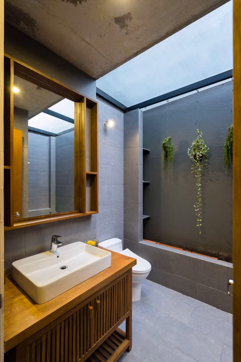Nhà vệ sinh cạnh phòng ngủ được trang trí với một vài giỏ hoa treo.