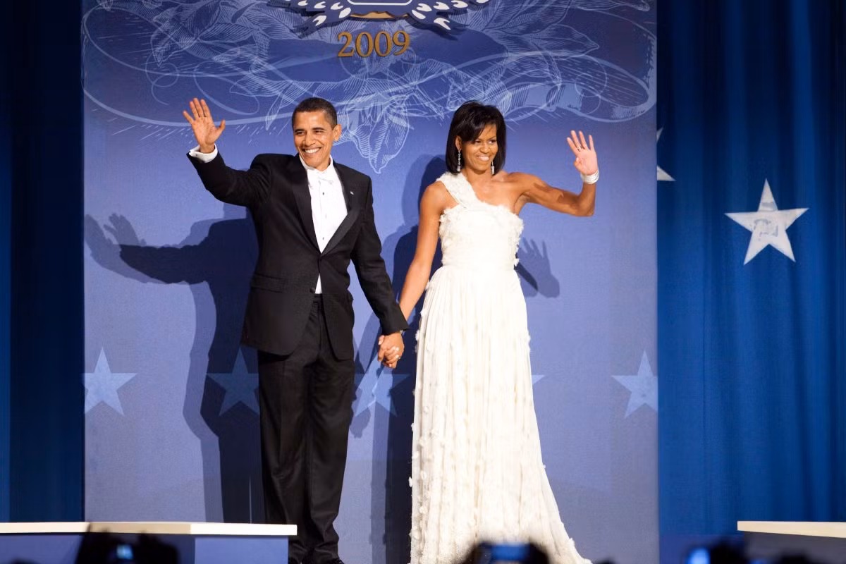 Đệ nhất phu nhân Mỹ Michelle Obama đã thực sự gây ấn tượng với phong cách thời trang hàng hiệu phù hợp mỗi lần xuất hiện trong các sự kiện chính thức. Ảnh: Vợ chồng ông Obama tại tiệc khiêu vũ mừng lễ nhậm chức tổng thống ngày 20/1/2009. Bộ váy trắng đính pha lê Swarovski của bà Michelle do nhà thiết kế Jason Wu thực hiện.