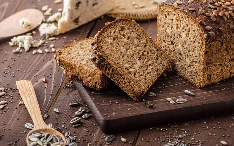 2. Ăn bánh mì ngũ cốc nguyên hạt thay vì loại đã qua chế biến. Trái ngược với các loại hạt đã qua chế biến, các loại ngũ cốc nguyên hạt thường đi kèm với nhiều lợi ích về mặt sức khỏe, bao gồm cả giảm nguy cơ mắc tiểu đường loại 2, bệnh tim mạch và ung thư. Chúng đồng thời cũng rất giàu chất sơ, vitamin B và nhiều khoáng chất như kẽm, sắt, magiê và mangan.