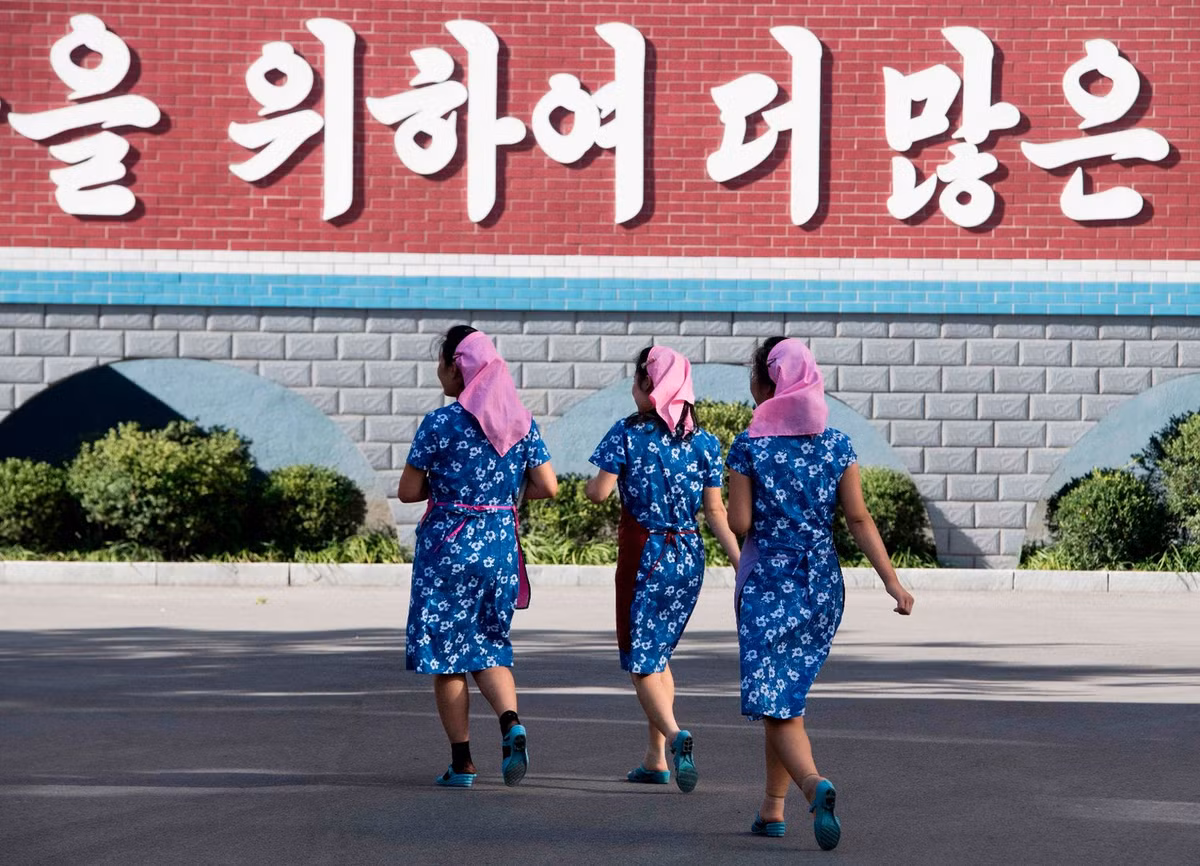 Các nữ công nhân nhanh chân tới nơi làm việc của họ tại nhà máy lụa Kim Jong Suk.