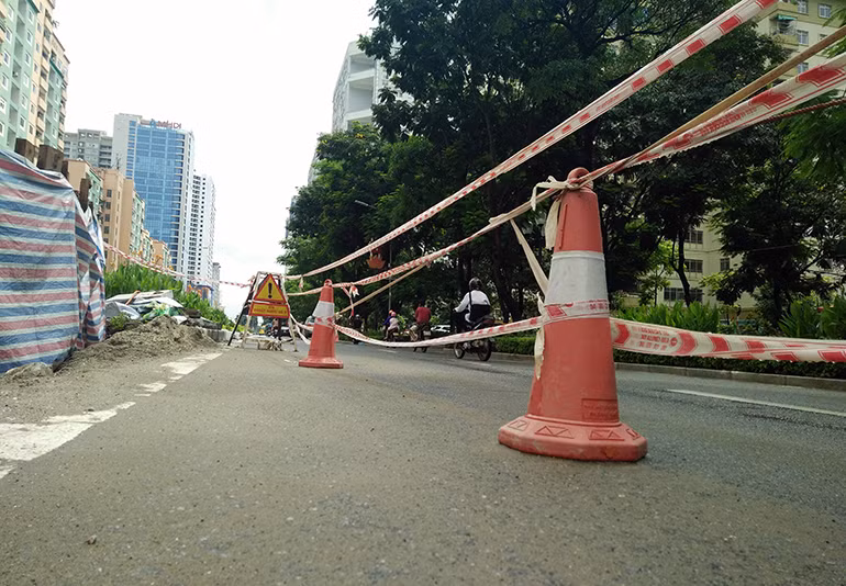 Các biển báo "Xí nghiệp thoát nước số 2" và dây công trình được kéo xung quanh khu vực bị sạt lở cảnh báo người đi đường biết.