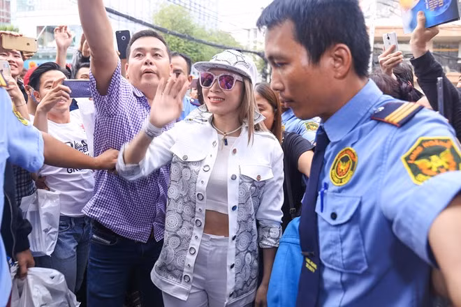 Không ngại trời nắng hanh của buổi giữa trưa, các fan chen nhau đứng kín khu vực trước sân khấu để chờ đến lượt bước vào buổi ký tặng. Hình ảnh này khiến nhiều người đi đường tò mò và dừng xe để cố nhìn nữ ca sĩ nổi tiếng.