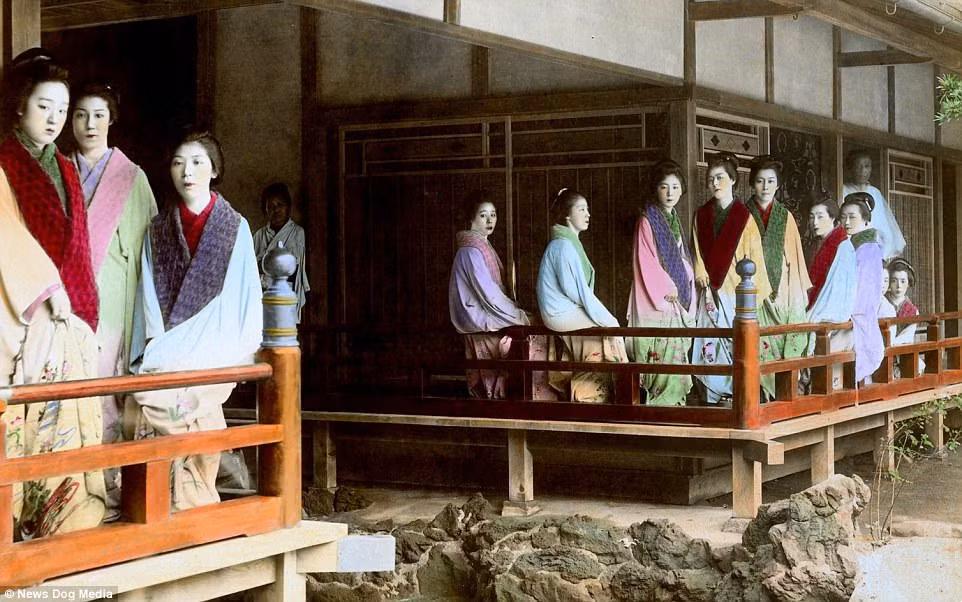 Các kỹ nữ đứng bên ngoài nhà thổ tại Yoshiwara. Khu phố đèn đỏ Yoshiwara hoạt động cho tới năm 1958. Sau đó, chính phủ Nhật Bản ra lệnh cấm.
