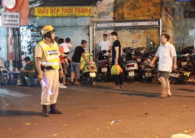 Tại các điểm giao nhau với khu vực phố cấm, CSGT đứng chốt chặn để nhắc nhở, hướng dẫn người đi xe máy, ôtô gửi hoặc dắt xe vào khu vực diễn ra Không gian đi bộ.