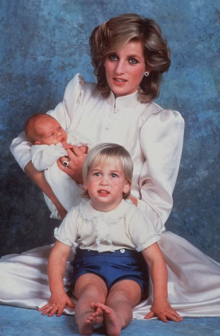 Công nương Diana chụp ảnh cùng hai con trai là Hoàng tử William, lúc đó 2 tuổi, và Hoàng tử Harry trong lễ rửa tội của Harry năm 1984. Đây là bức ảnh chụp chung đầu tiên của hai anh em William-Harry. (Nguồn ảnh: Insider)