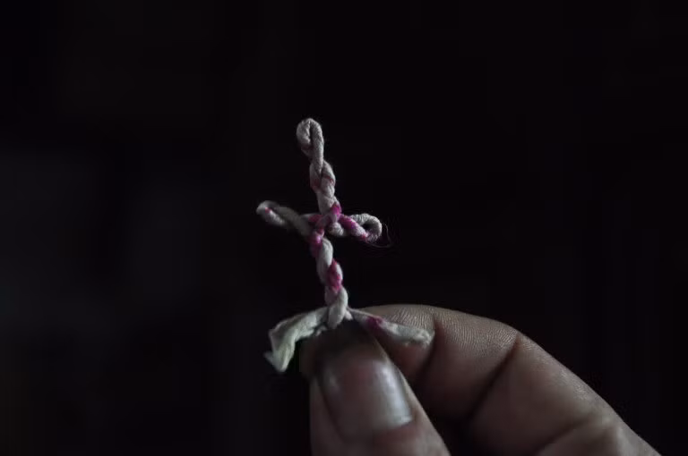 Lá bùa hình người được phát cho người dân đến “trấn trùng” tại chùa Hàm Long