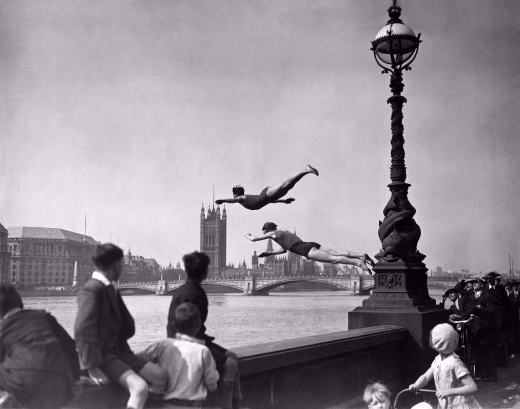 Nhiều người dân đứng trên cầu theo dõi các thợ lặn làm việc ở sông Thames năm 1934.
