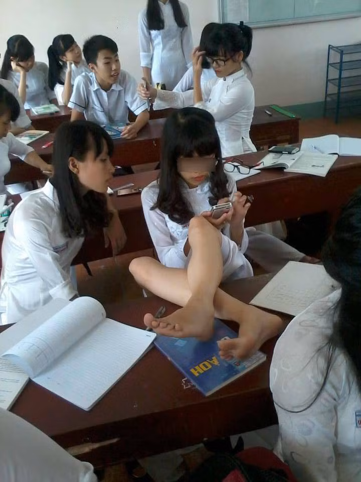 Nữ sinh mặc áo dài ngồi "kém duyên" trong lớp học.