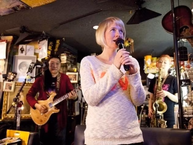 Studio Himawari: Karaoke là "món ăn" đêm được ưa chuộng ở thủ đô Tokyo. Tọa lạc trong khu vực Kabukicho, Shinjuku, Studio Himawari mang đến cho bạn cảm giác được một lần thử lầm ngôi sao nhạc rock. Điểm đến này sở hữu một sân khấu nhỏ cùng ban nhạc đánh guitar điện và thổi kèn saxophone... nhằm phục vụ yêu cầu của du khách. Thức ăn và rượu vang luôn phục vụ buổi hòa nhạc tới 7h hôm sau. Ảnh: Yelp, Timeout.