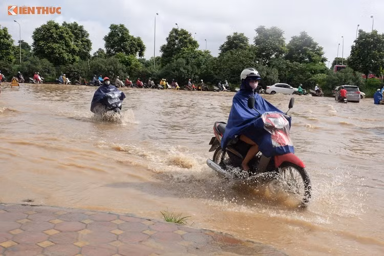 Sau cơn mưa lớn ngày 13/7, đại lộ Thăng Long (Hà Nội) ngập úng nặng, giao thông cửa ngõ phía Tây đoạn qua cổng chào Thiên đường Bảo Sơn tê liệt nhiều giờ.