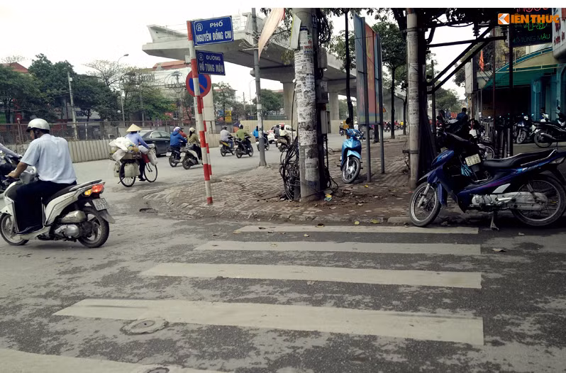 Điểm đầu phố Nguyễn Đồng Chi giao với đường Hồ Tùng Mậu (Hà Nội), vạch kẻ đường cũng bị chặn bởi các cột điện, cột biển báo...