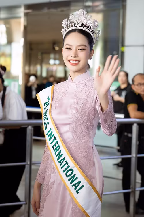 Tại sân bay quốc tế Tân Sơn Nhất, người đẹp diện trang phục áo dài truyền thống, đội vương miện.