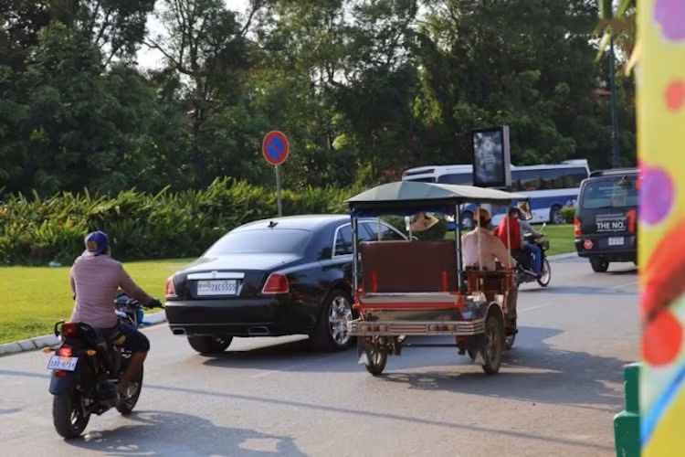 Rolls-Royce Ghost hoà lẫn với xe lam và xe máy trên đường.