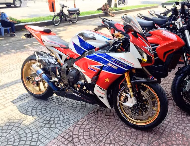 Dàn áo với tem đấu HRC 3 màu trắng-đỏ-xanh đặc trưng của phiên bản FireBlade SP vẫn được giữ nguyên, tuy nhiên chủ xe đã dán thêm một số decal trang trí mang các nhãn hiệu khác nhau.