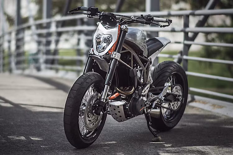 Phần đầu xe được lấy từ mẫu KTM 690 Duke nhưng chỉ giữ lại đèn pha, toàn bộ phần nhựa xung quanh cũng đã bị vứt bỏ và thay bằng một tấm nhôm dập theo viền đèn.