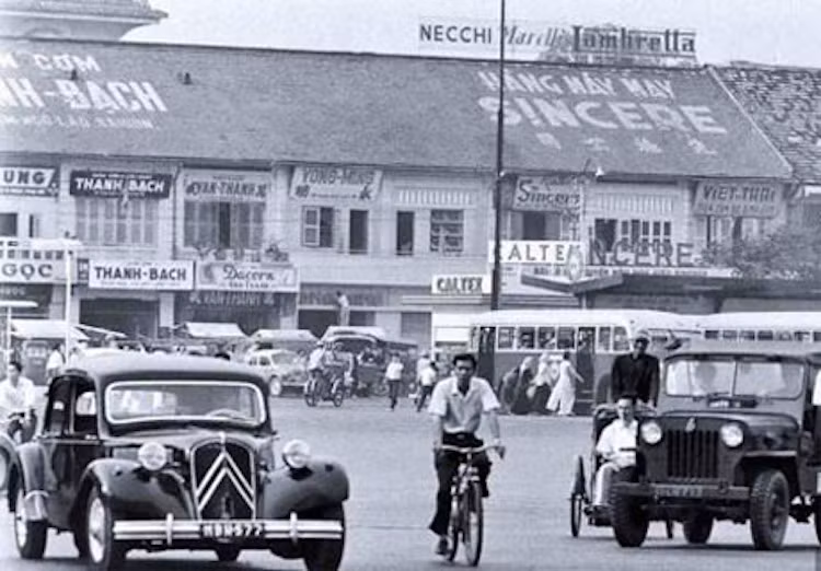 Người đi xe đạp nằm "lọt thỏm" giữa Citroen "Tắc-xông" Traction và xe Jeep quân sự.