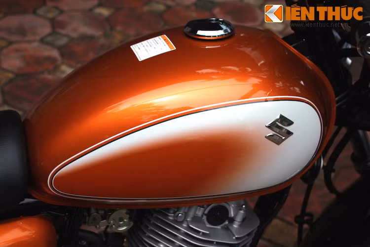 Tem bình xăng đơn giản nhưng sang trọng với màu cam chuyển dần sang trắng và logo chữ S nổi của Suzuki.