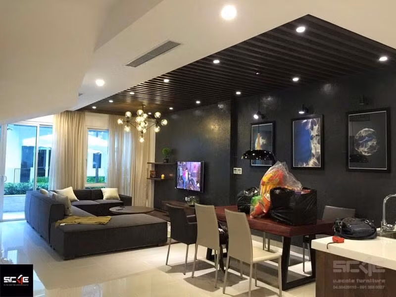 Tổng thể tạo điểm nhấn cho phòng khách thông với phòng ăn là mảng tường màu nâu trầm sơn sần.