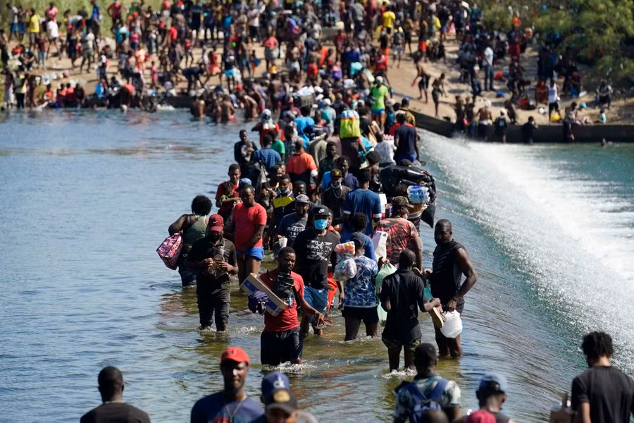 Hình ảnh đám đông người tị nạn Haiti đi bộ dọc theo một đập trên sông Rio Grande ở Del Rio, Texas (Mỹ) được chụp lại vào ngày 17/9, bât chấp sự ngăn chặn của các nhân viên Hải quan và Biên phòng Mỹ.
