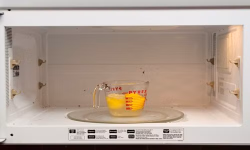 Để làm sạch lò vi sóng, bạn đun nóng một cốc nước có vài lát chanh nhỏ bên trong cho đến khi cửa lò vi sóng dính hơi nước. Để khoảng 15 phút rồi lau lại bằng khăn ẩm.