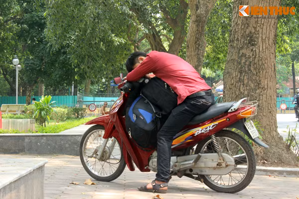 Nam thanh niên đi đường mệt mỏi vì nắng nóng nên tranh thủ chợp mắt dưới bóng cây râm mát.