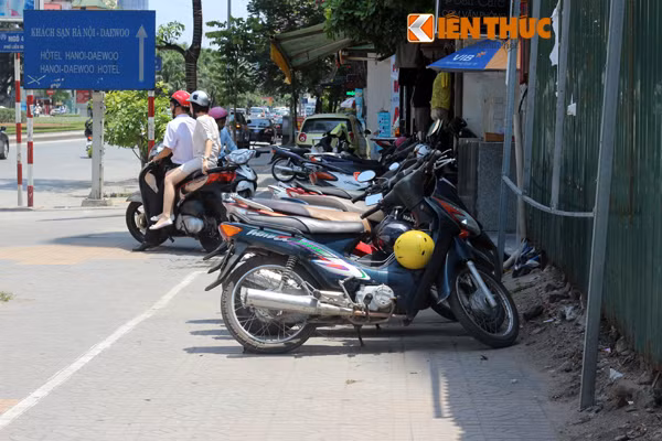 Ảnh chụp một người phụ nữ phải ngồi nhấp nhổm vì yên xe nóng bỏng. Nắng nóng không chỉ khiến chị em phụ nữ mà ngay cả đàn ông cũng khó chịu khi ngồi lên xe. "Tôi chạy xe ôm, để xe trong bóng cây mà yên cũng nóng bỏng mông rồi, nói gì để xe phơi ngoài nắng", ông Hoàng Văn Nam - một lái xe ôm trên đường Cầu Giấy, chia sẻ.