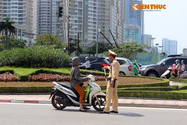 Trao đổi với PV Kiến Thức, Thiếu úy Nguyễn Văn Kiên, Đội CSGT số 6, CA TP Hà Nội cho biết: "Ùn tắc giao thông tại điểm này thường xảy ra vào lúc 8h sáng và từ 16h30 chiều các ngày trong tuần. Nhiều hôm chúng tôi buộc phải gọi lực lượng tăng cường đến giúp đỡ (điểm giao thông có 4 đồng chí, chia nhau ra làm 2 ca). Mấy ngày nay nắng nóng kinh hoàng thật nhưng anh em chúng tôi cũng quen, vì đó là công việc". Ảnh: Thiếu úy Nguyễn Văn Kiên đang làm nhiệm vụ.