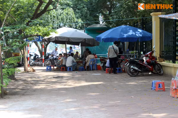 Bên cạnh "sở thích kì dị" uống trà đá cạnh những xe, thùng rác, nhiều người ở Hà Nội còn thích tụ tập ở các quán nước cạnh nhà vệ sinh công cộng để nhâm nhi ly trà đá. Ảnh chụp một quán trà đá nằm sát toilet công cộng trước cửa Công viên Nghĩa Đô (Cầu Giấy, Hà Nội).