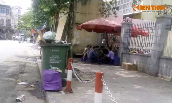 Ở trước cửa Công viên Đống Đa, một quán trà đá chỉ cách thùng chứa đầy ắp rác khoảng 3m cũng thu hút được khá nhiều khách hàng, chủ yếu là thanh niên.