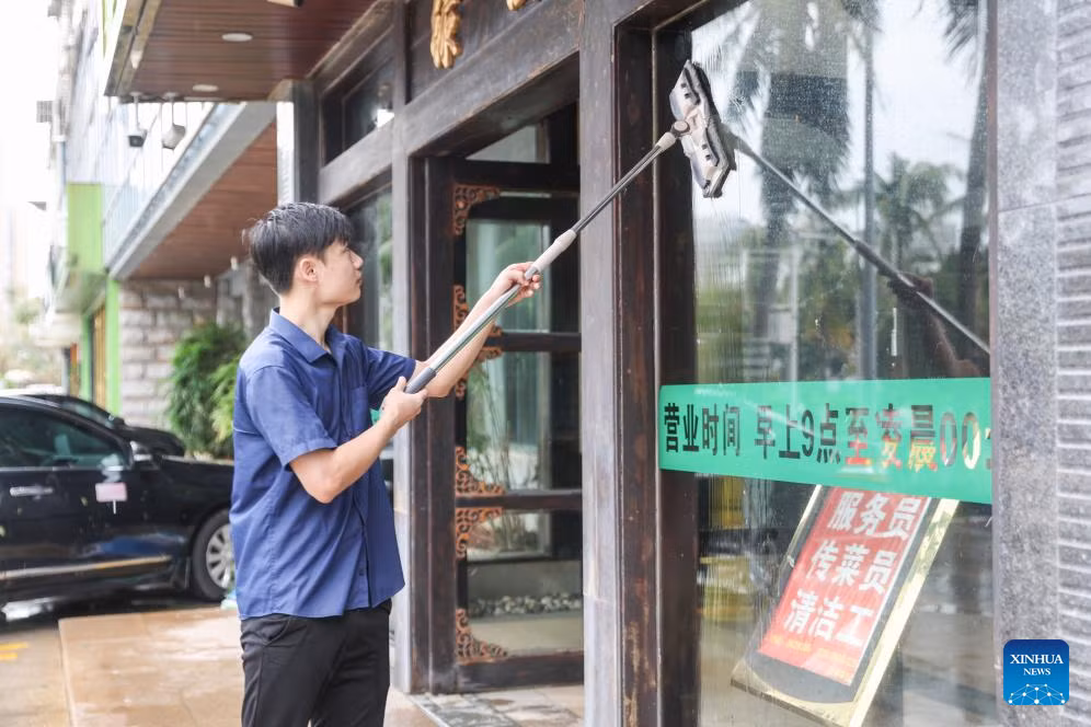 Một người đàn ông lau cửa của một nhà hàng ở Hải Khẩu, tỉnh Hải Nam, ngày 7/9.