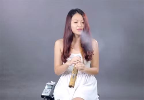 Một bạn nữ thử sức với việc hút thuốc lào trong 1 chương trình trải nghiệm.