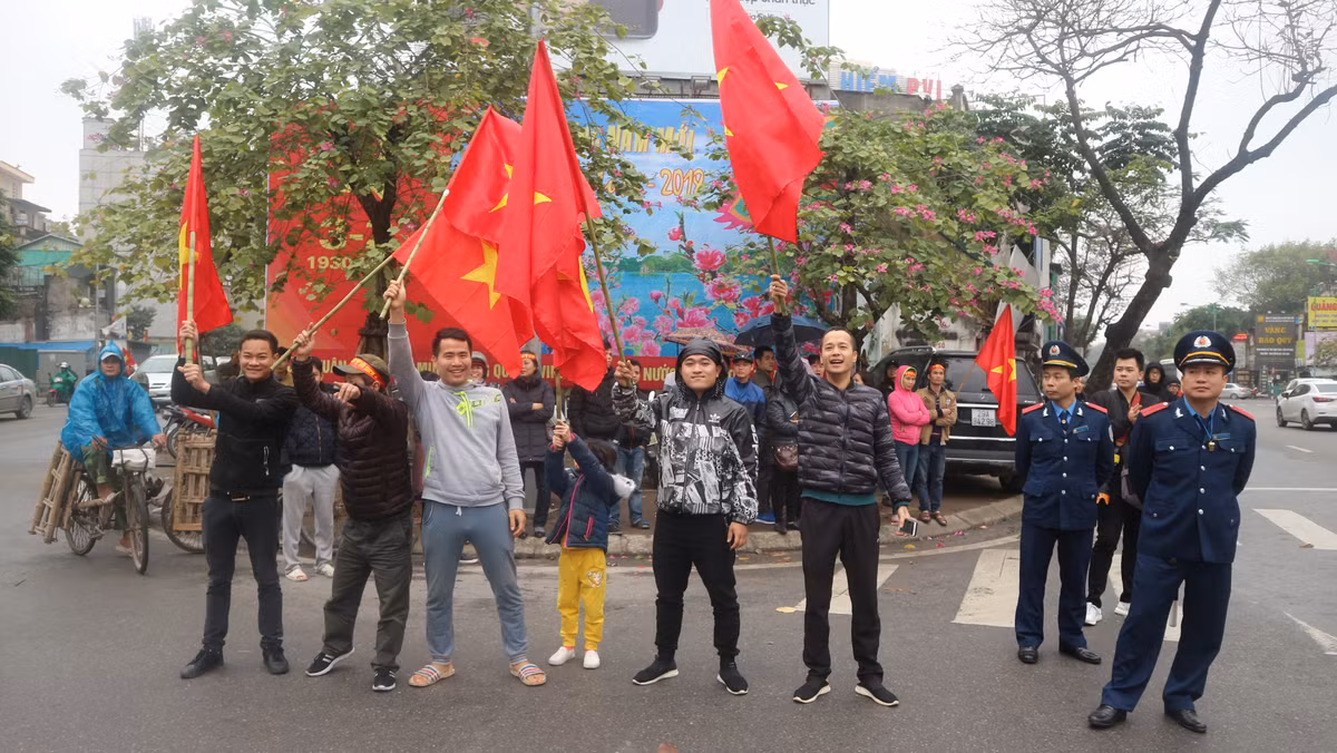 Những chiếc cơ, băng rôn được người dân đứng hai bên đường Kim Mã chuẩn bị sẵn để đón các cầu thủ.