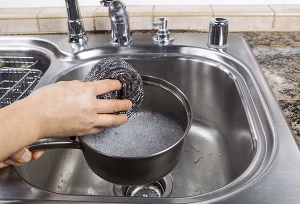 Sai: Nếu chảo bẩn và nhiều thứ cặn bám kỹ quá, dùng búi cọ nồi bằng sắt cọ sạch.