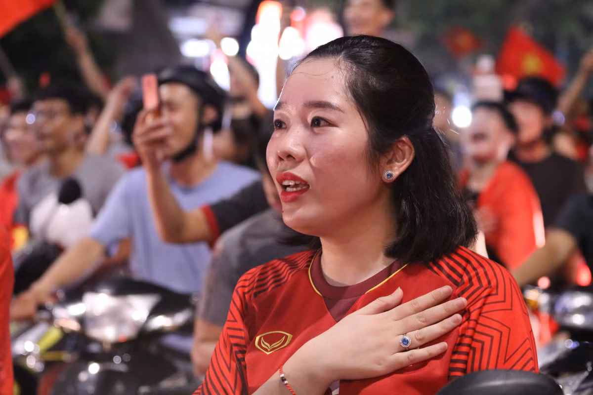 Một nữ CĐV rất tâm trạng trong bài Quốc ca được mở trên phố giữa dòng người đông đúc.