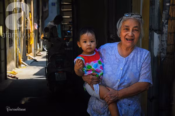 Bà cụ bế cháu ra ngõ đón chút ánh nắng.